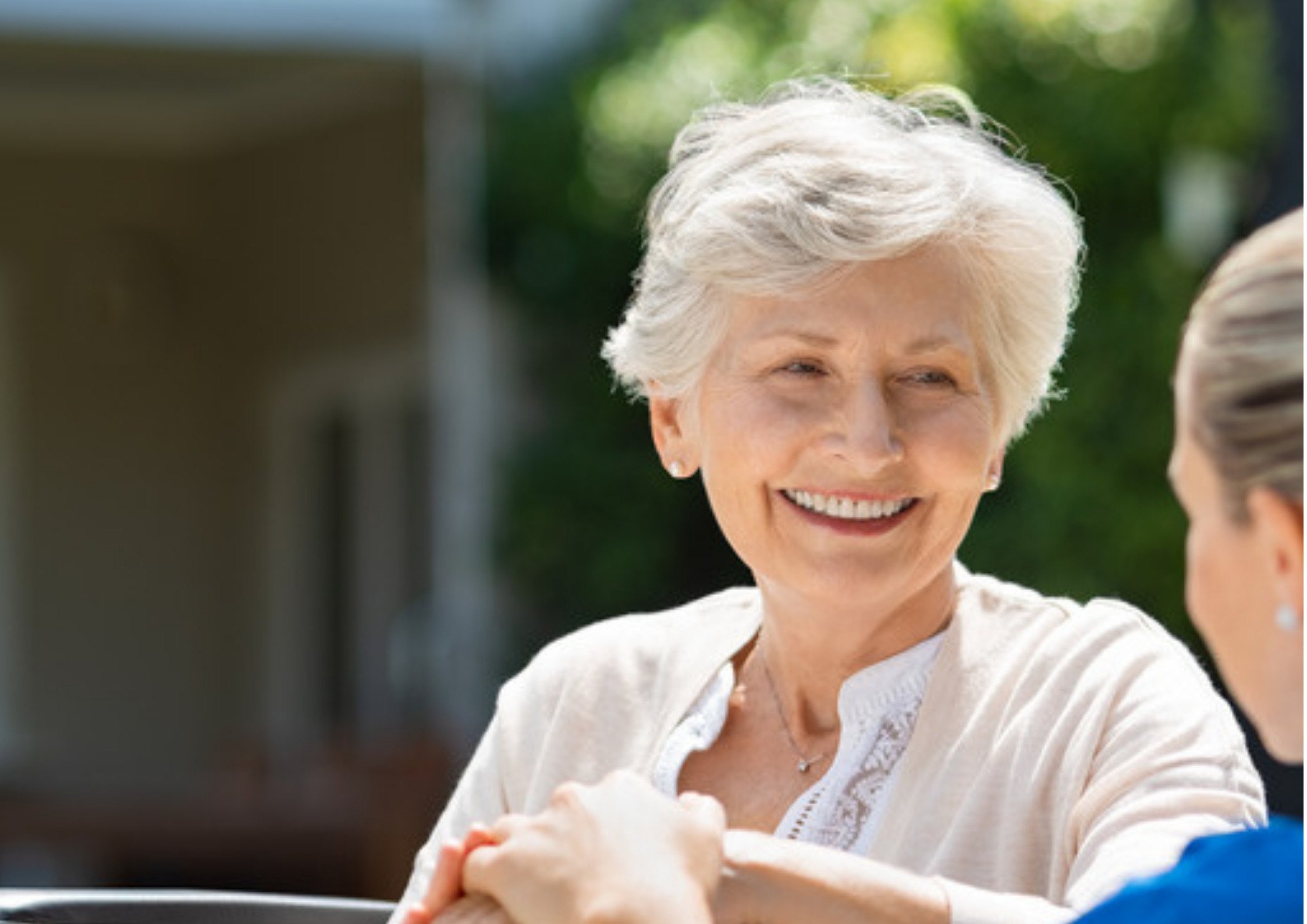 A carer sharing a laugh with an elderly resident in a care home